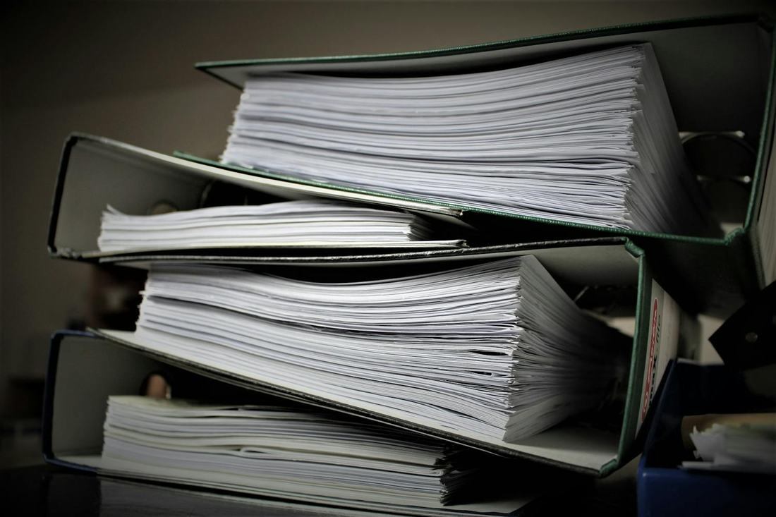 Binders with paper records prepared for packet indexing